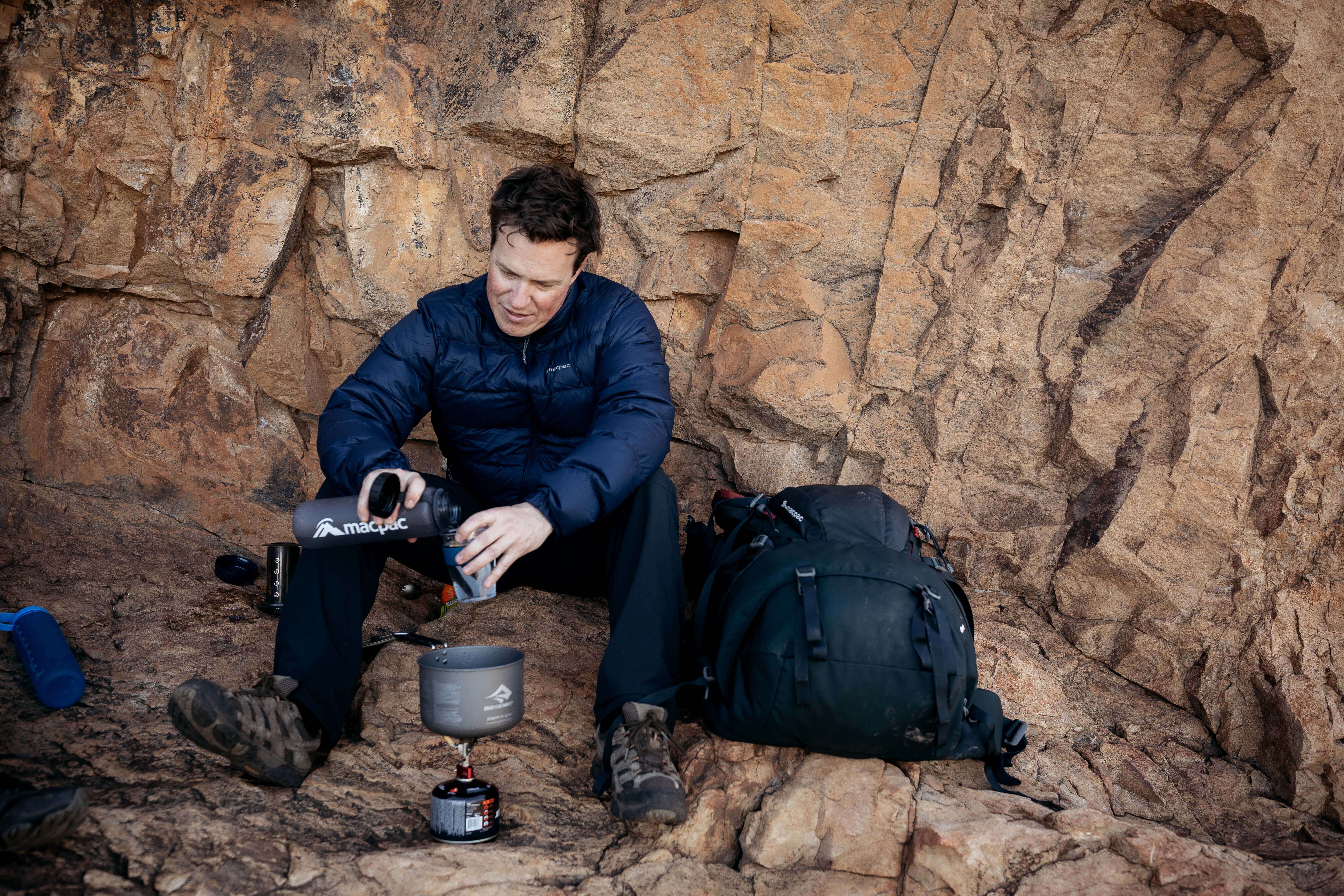 Man making a coffee during hike